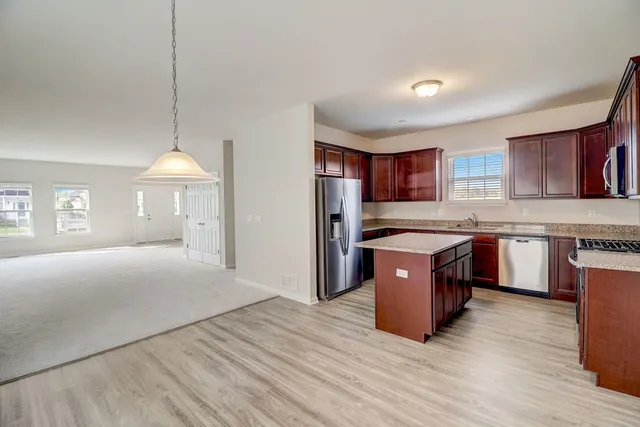 a large kitchen with stainless steel appliances granite countertop a stove a sink dishwasher and a refrigerator