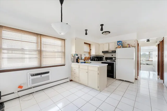 a kitchen with white cabinets and white appliances