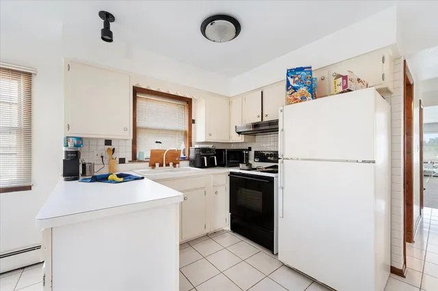 a kitchen with a refrigerator sink stove and cabinets