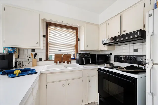 a kitchen with a sink dishwasher a stove and a refrigerator with wooden cabinets