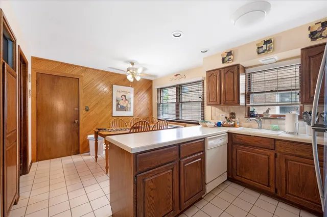 a kitchen that has a lot of cabinets in it and stainless steel appliances