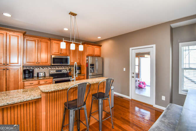 290 Eli Knob Road Dahlonega, GA 30533 - Photo 8 of 87 a kitchen with stainless steel appliances granite countertop a stove top oven a sink dishwasher and a microwave with wooden floor