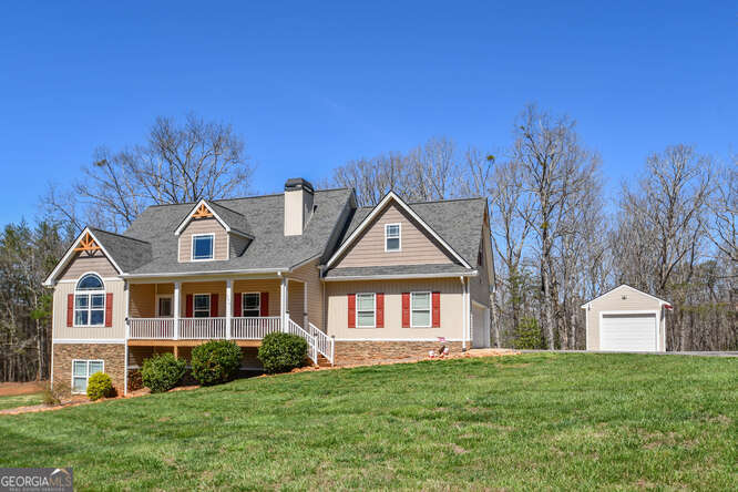 290 Eli Knob Road Dahlonega, GA 30533 - Photo 86 of 87 a front view of a house with a garden and yard
