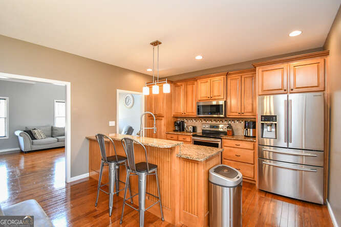 290 Eli Knob Road Dahlonega, GA 30533 - Photo 10 of 87 a kitchen with stainless steel appliances granite countertop a refrigerator a stove a sink dishwasher a dining table and chairs with wooden floor