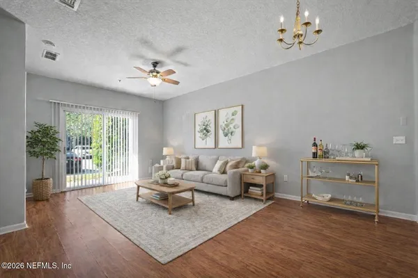 a living room with furniture a chandelier and a window