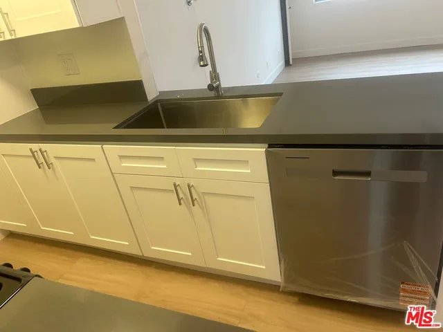 a view of a room with wooden floor and a refrigerator