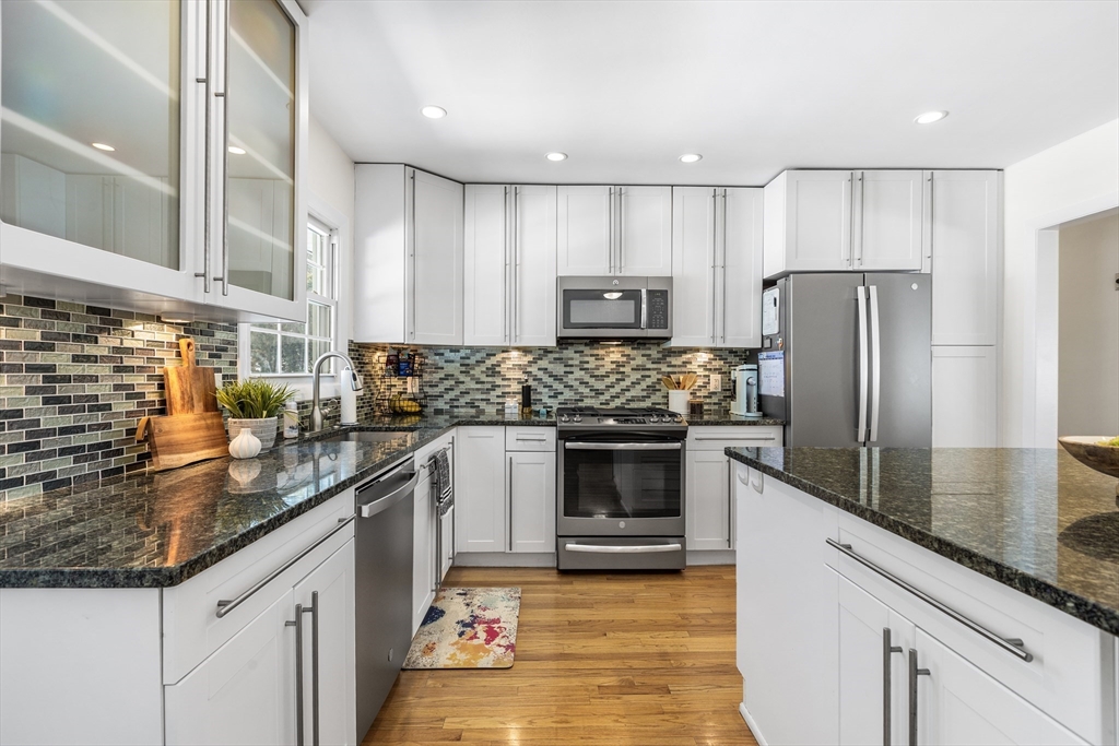 27 Audubon Road Reading, MA 01867 - Photo 13 of 35 a kitchen with granite countertop stainless steel appliances a sink a counter top space and cabinets