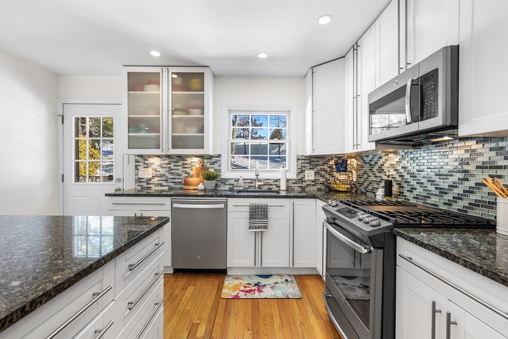 27 Audubon Road Reading, MA 01867 - Photo 14 of 35 a kitchen with stainless steel appliances granite countertop a stove a sink and a microwave