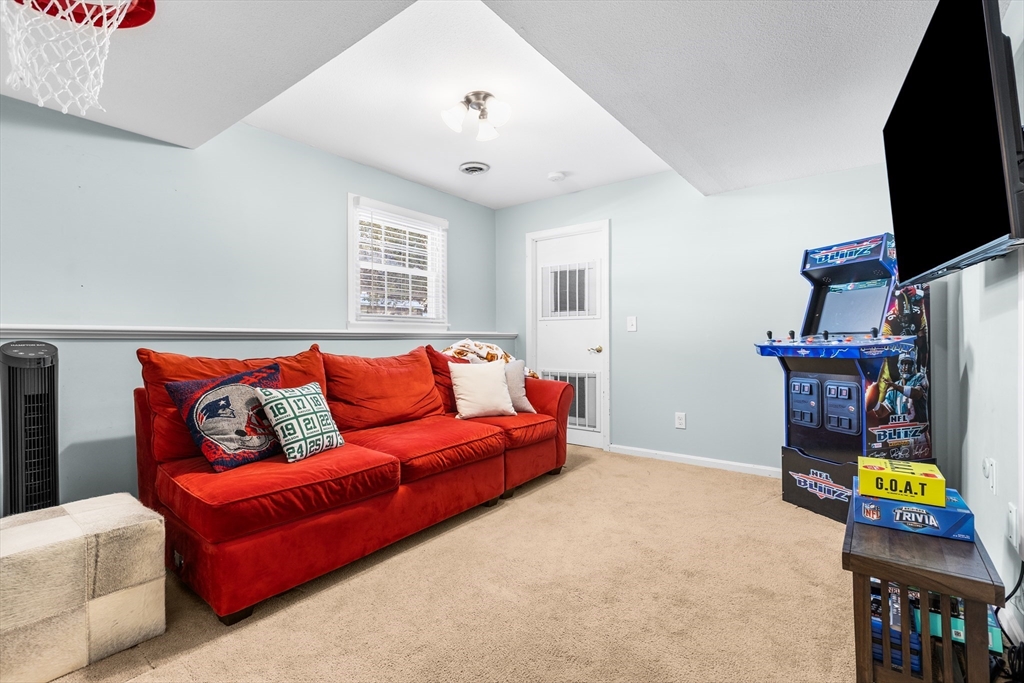 27 Audubon Road Reading, MA 01867 - Photo 28 of 35 a living room with furniture and a flat screen tv