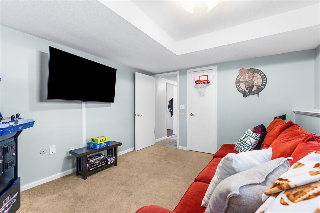27 Audubon Road Reading, MA 01867 - Photo 29 of 35 a bedroom with a bed a flat screen tv and a couch