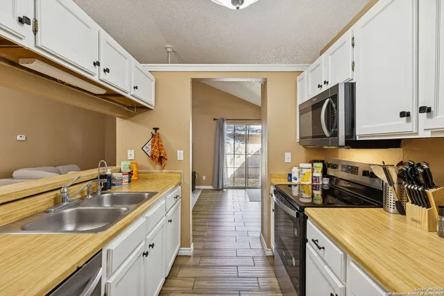 a kitchen with a sink stove top oven and microwave
