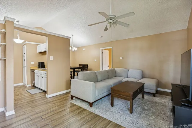 a living room with furniture and a view of kitchen
