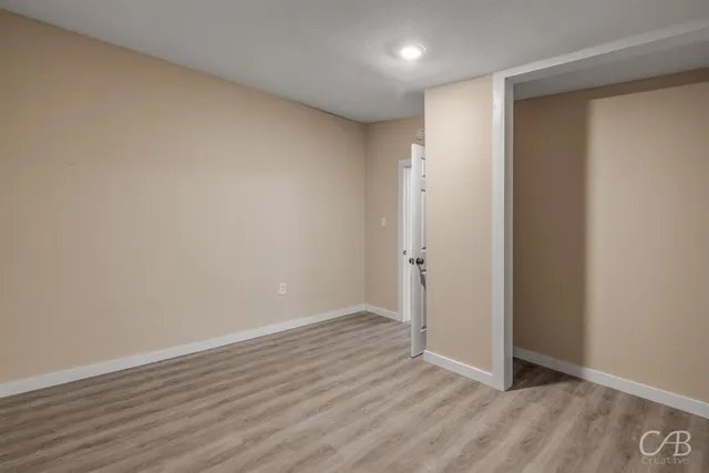 a view of an empty room with wooden floor