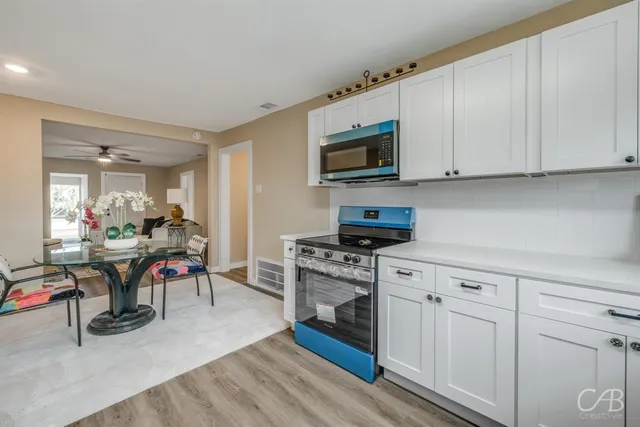 a view of kitchen with sink microwave and cabinets