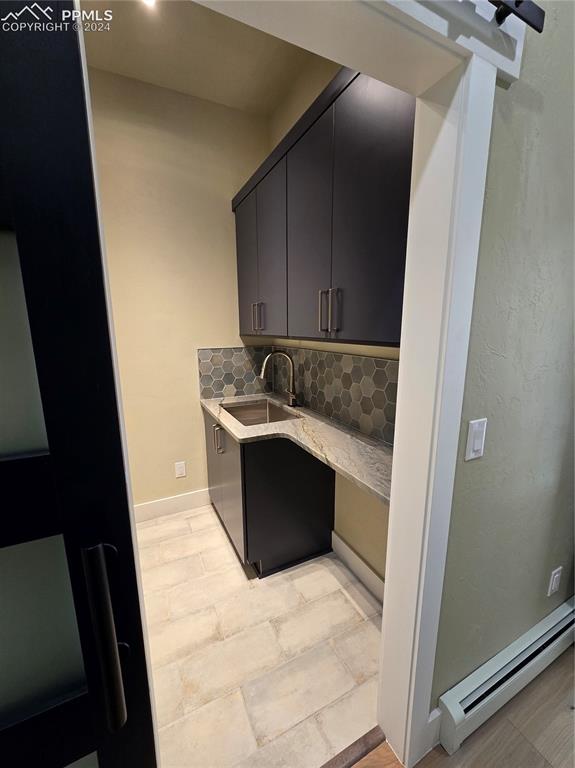 33036 Meadow Ridge Lane Trinidad, CO 81082 - Photo 26 of 50 Laundry room featuring a baseboard heating unit, sink, and decorative backsplash