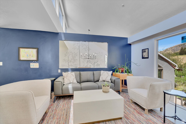 510 Spring Creek Road Providence, UT 84332 - Photo 13 of 97 Living area featuring a vaulted ceiling with clerestory windows, a large picture window, and a decorative wall mirror