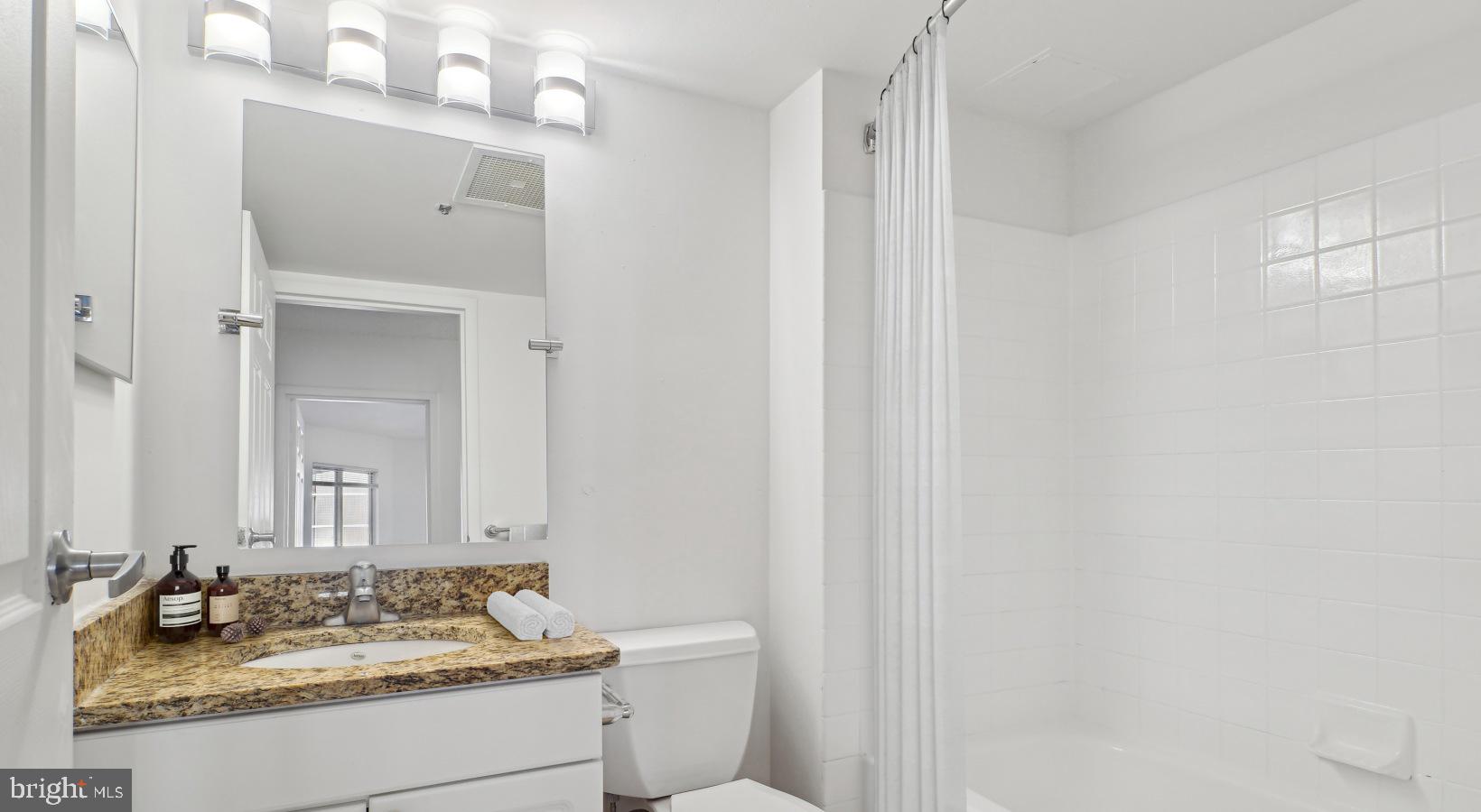 450 North 18th Street, Unit 2B1510 Philadelphia, PA 19130 - Photo 37 of 44 a bathroom with a granite countertop sink and a mirror