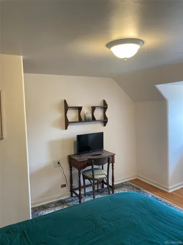 a view of a workspace with furniture and wooden floor