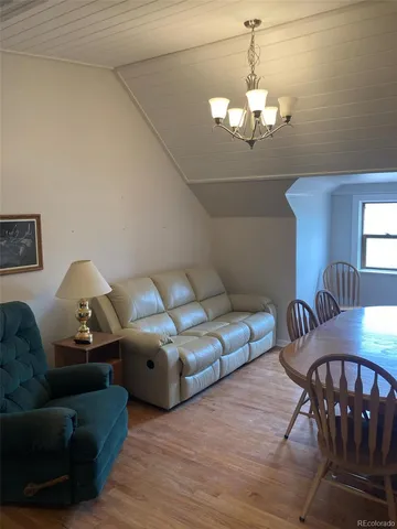 a living room with furniture chandelier and a table