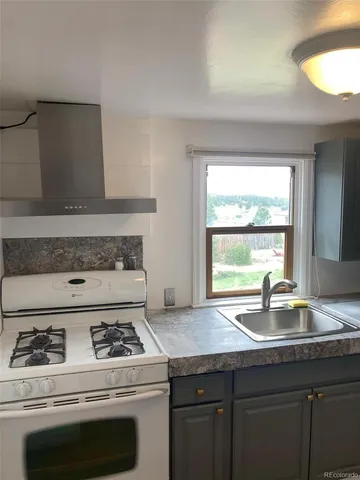a stove top oven sitting inside of a kitchen