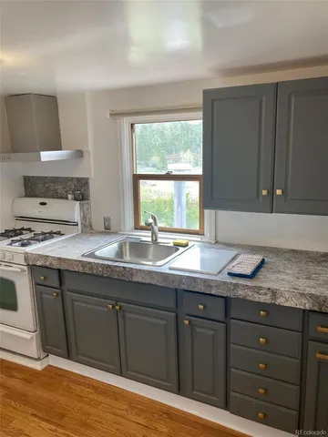 a kitchen with granite countertop a sink cabinets and window