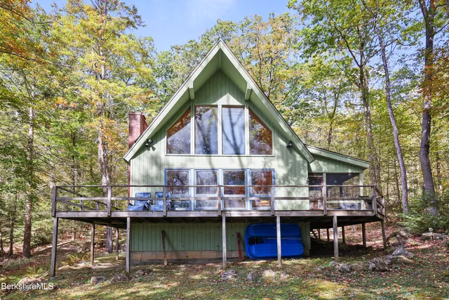 a view of house with roof deck and sitting area