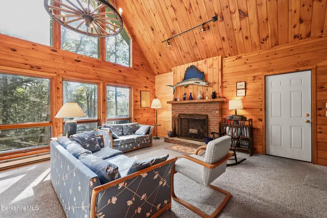 a living room with furniture a large window and a fireplace
