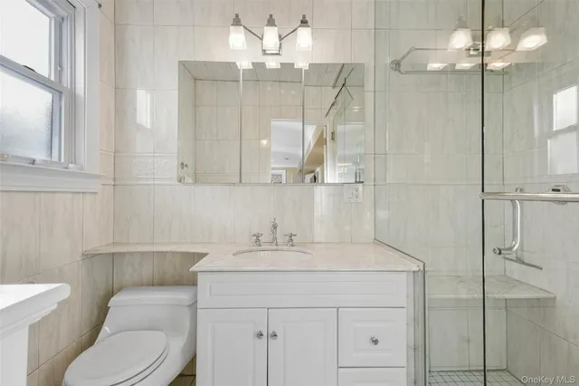 a bathroom with a sink toilet vanity and shower