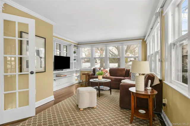 a living room with furniture a flat screen tv and a floor to ceiling window