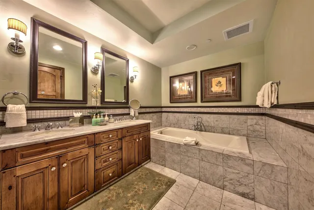 a spacious bathroom with a large tub sink and mirror