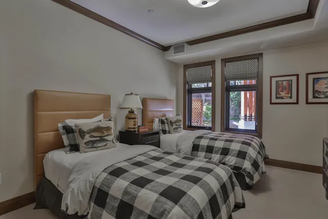 a bedroom with two beds and a large window