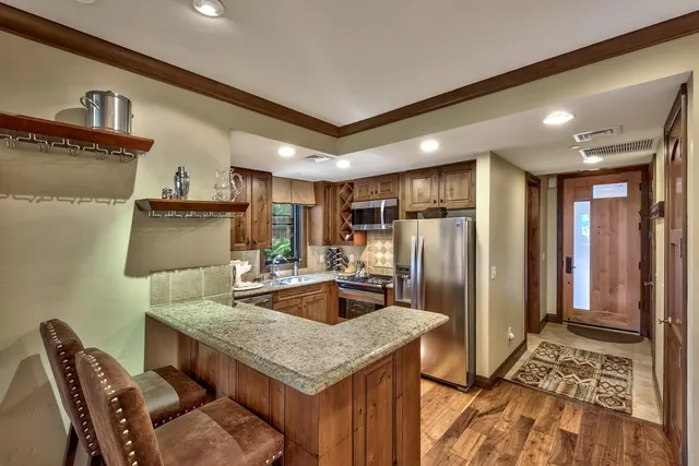a kitchen with stainless steel appliances granite countertop a sink refrigerator and cabinets