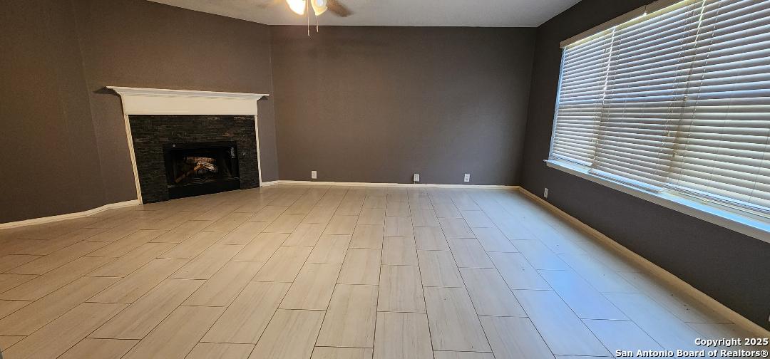 15710 Robin View San Antonio, TX 78255 - Photo 2 of 26 a view of an empty room with a fireplace and a window