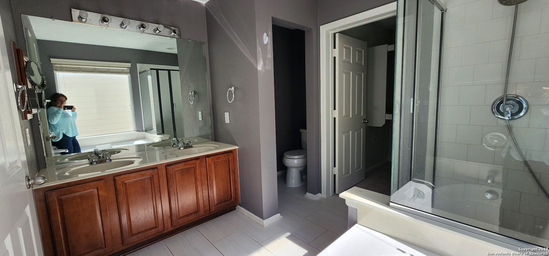 15710 Robin View San Antonio, TX 78255 - Photo 22 of 26 a bathroom with a granite countertop sink vanity mirror and shower