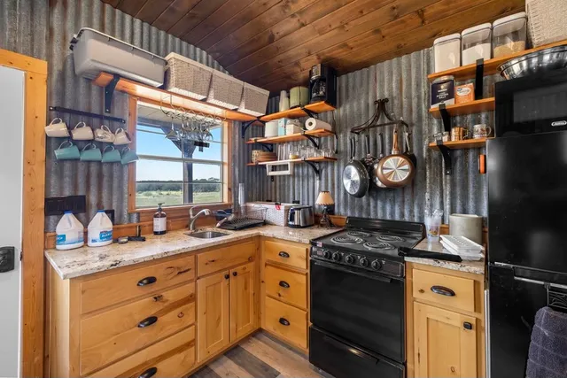 a kitchen with stainless steel appliances granite countertop a stove a washer and dryer