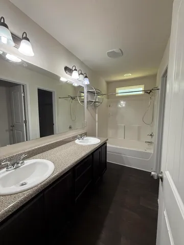 a bathroom with a granite countertop sink a mirror and a bathtub