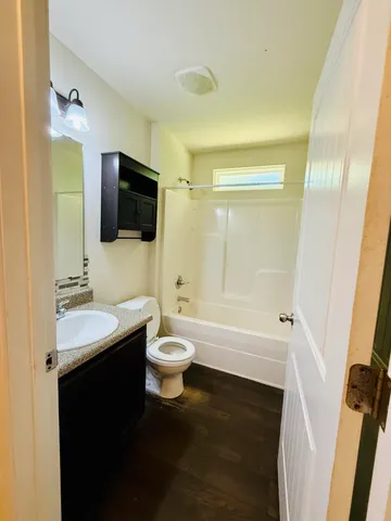 a bathroom with a sink a toilet a mirror and shower