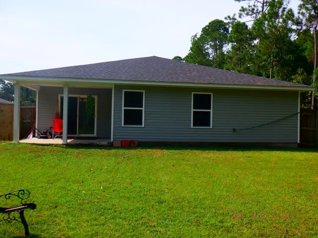 a view of a house with backyard and porch