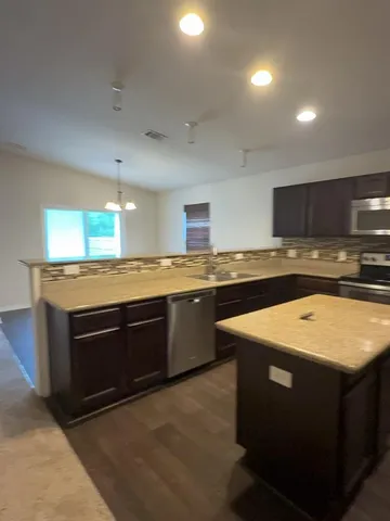 a kitchen with stainless steel appliances granite countertop wooden cabinets and a sink