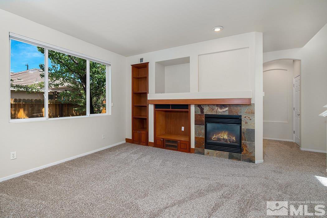 9646 Otter Way Reno, NV 89521 - Photo 6 of 25 a view of an empty room with a fireplace and a window