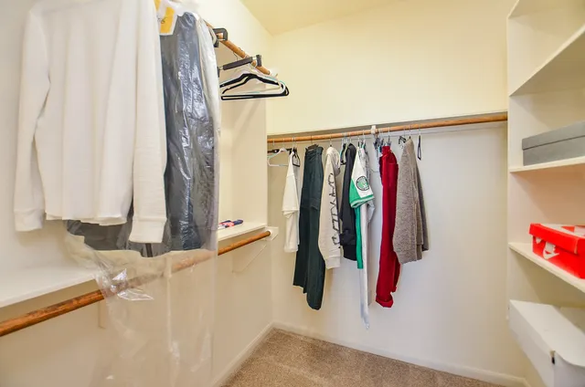 a view of walk in closet with clothes