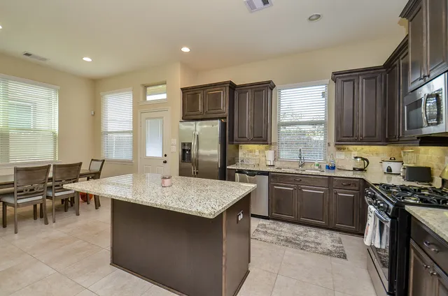 a kitchen with a stove a sink a dining table and chairs
