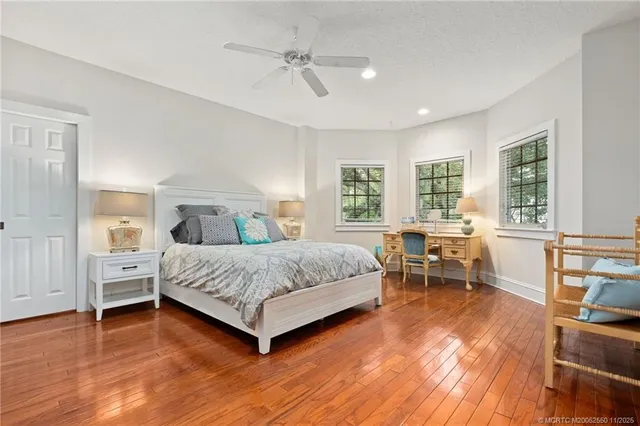 a bedroom with a bed and large windows