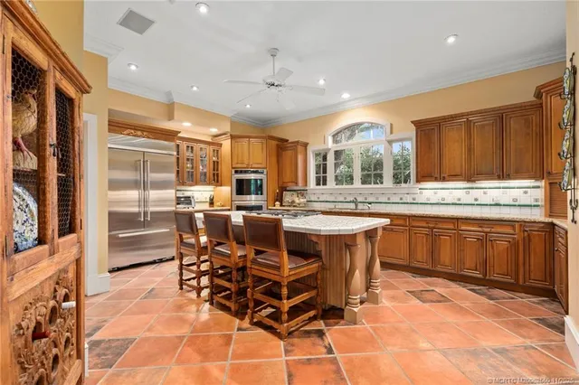 a kitchen with a sink table and chairs