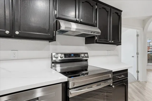a kitchen with wooden cabinets and a stove top oven