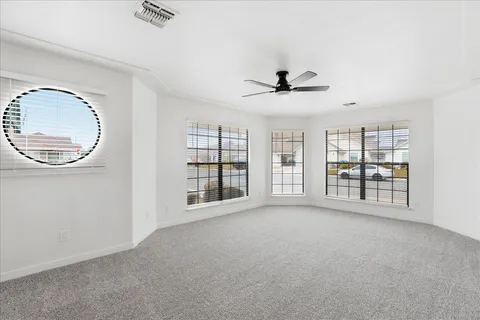 a view of an empty room with a window and a kitchen