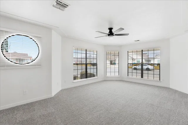 a view of an empty room with a window and a kitchen