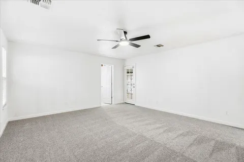 an empty room with a ceiling fan and a window