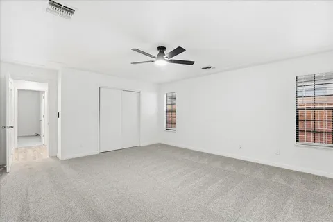an empty room with closet and windows