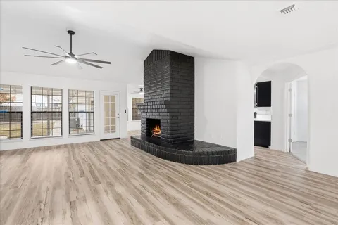 a view of a livingroom with wooden floor and a fireplace